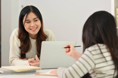 Gülümseyen anne ve küçük kız ödevlerini yapıyor, evde öğreniyor. Evde eğitim kavramı.