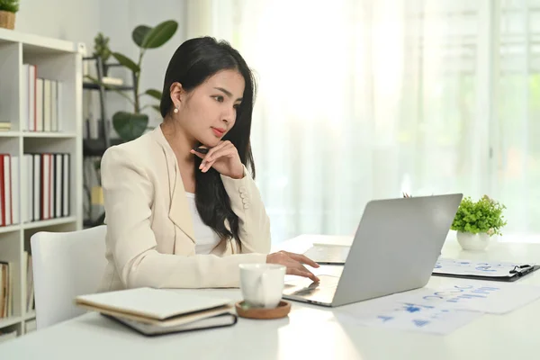 魅力的なアジアの女性起業家は ラップトップコンピュータを介してインターネット上で通信し オンラインクライアントとチャット — ストック写真