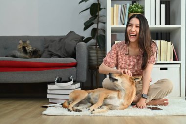 Mutlu genç bayan sahibi evde sevimli köpekle oynamaktan zevk alıyor. Dostluk, ilişkiler, sonsuza dek en iyi arkadaş..