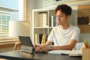 Odaklanmış bir adam dizüstü bilgisayardan eğitici web sitelerini izliyor. Çevrimiçi eğitim, e-öğrenim ve evde eğitim kavramı.