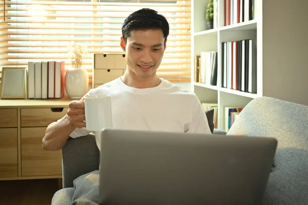 Gelukkig Aziatische Mannelijke Freelancer Met Een Kopje Koffie Met Behulp — Stockfoto