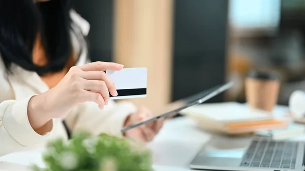 stock image Cropped shot of woman hand holding credit card making transaction or shopping online on digital tablet.