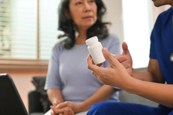 高齢患者に説明する薬瓶を持っている医療従事者 在宅医療サービスの概念 — ストック写真