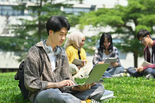Joven Asiático Hombre Estudiante Usando Portátil Verde Hierba Frente Universidad — Foto de Stock
