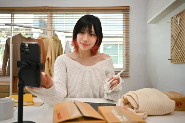 カジュアルな服装で若いアジアの女性の中小企業のオーナーとオンラインストアで顧客の住所や注文をチェック — ストック写真