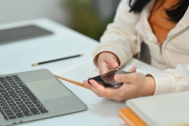 Genç bir kadın cep telefonundan mesaj yolluyor. İletişim, teknoloji ve yaşam tarzı kavramı.