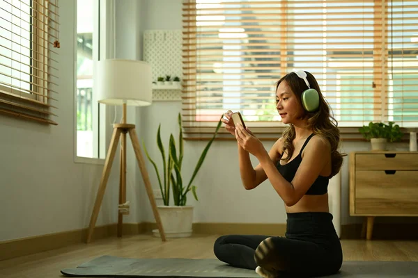 Atractiva Deportista Que Usa Auriculares Usando Teléfono Inteligente Una Esterilla — Foto de Stock