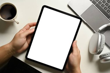 Beyaz ofis masasında oturan ve dijital tablet kullanan adamın yakın görüntüsü. Metin reklamı için boş ekran.