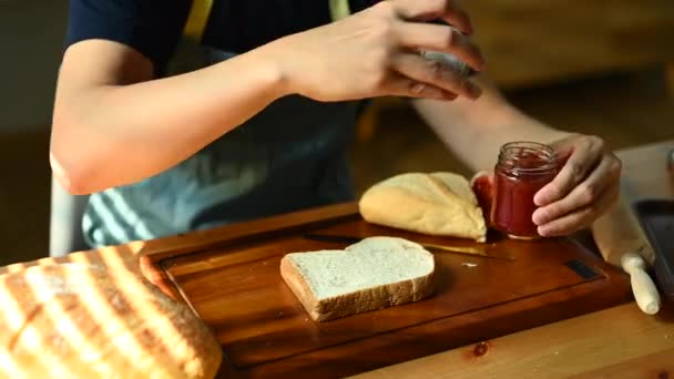 Człowiek Fartuchu Przygotowuje Śniadanie Rozsypuje Dżem Malinowy Plasterku Chleba Nożem — Wideo stockowe