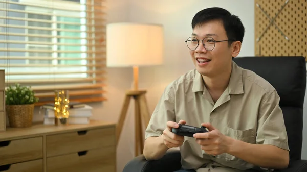 stock image Happy man holding wireless controller playing video game. Entertainment, technology and hobby concept.