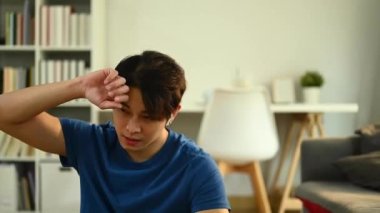 Spor yaptıktan sonra dinlenen, alnından ter silen yorgun ve sportif erkek pozu. Sağlıklı yaşam tarzı ve uygunluk kavramı.