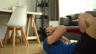 Formda atletik Asyalı adam oturma odasında paspasın üzerinde çapraz çıtırtı egzersizi yapıyor. Fitness, eğitim ve sağlıklı yaşam tarzı konsepti.