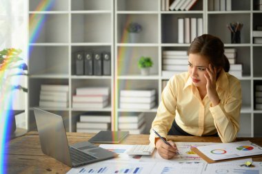 Yıkılmış milenyum kadın muhasebeci piyasa araştırmalarının sonuçlarını dizüstü bilgisayardan analiz ediyor..