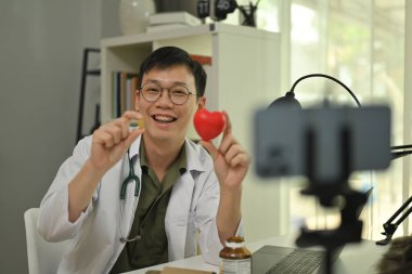 Neşeli doktor çevrimiçi sağlık dersi veya sanal konsültasyon için video kaydediyor. Sağlık, danışmanlık ve terapi konsepti.