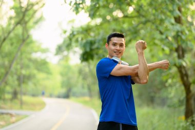 Spor antrenmanından önce yakışıklı bir koşucu ısınıyor. Fitness, spor ve sağlıklı yaşam tarzı kavramı.