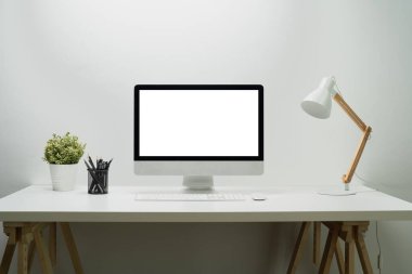 Masasında masaüstü bilgisayar ekranı olan modern bir iş yeri. Grafik görüntüleme için beyaz boş ekran.