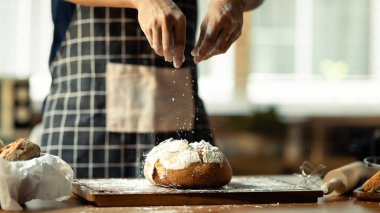 Önlüklü tanınmayan fırıncının beyaz unlu hamur tatlısı hazırladığı güzel bir an..