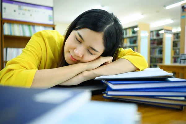 Unavená Studentka Spící Hromadě Knih Knihovně Rozmazanou Knihovnou Pozadí — Stock fotografie