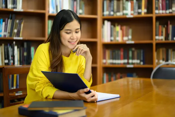 Güzel Asyalı Kadın Sınava Hazırlanırken Kütüphanede Oturup Ders Kitabı Okuyor — Stok fotoğraf