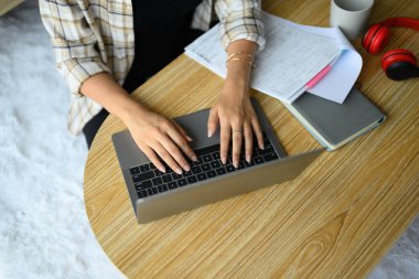 Yukarıdan bakıldığında dizüstü bilgisayarın klavyesinde yazarken, evde çalışırken çekilmiş..