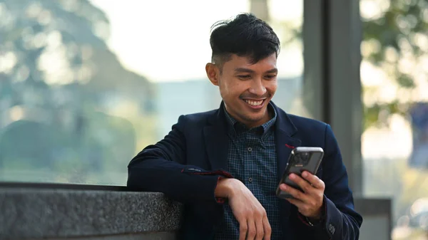 Χαμογελώντας Νεαρός Επιχειρηματίας Ντυμένος Επίσημα Ρούχα Κάθεται Εξωτερικούς Χώρους Στην — Φωτογραφία Αρχείου