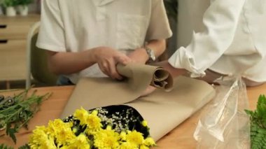 LGBT, aşk ve yaşam tarzı ilişki kavramı. Neşeli eşcinsel çift çiçek düzenliyor, evde birlikte iyi vakit geçiriyorlar..