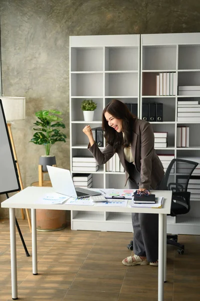 stock image Surprised start up businessman looking at laptop screen, making winner yes gesture, celebrating business success.