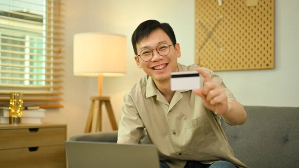 Boldog Fiatal Felnőtt Férfi Kezében Hitelkártya Laptop Segítségével Megrendelések Iinternet — Stock Fotó