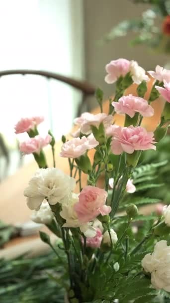 舒适的客厅里 漂亮的粉色玫瑰和康乃馨花束在木制桌子上的花瓶里 — 图库视频影像