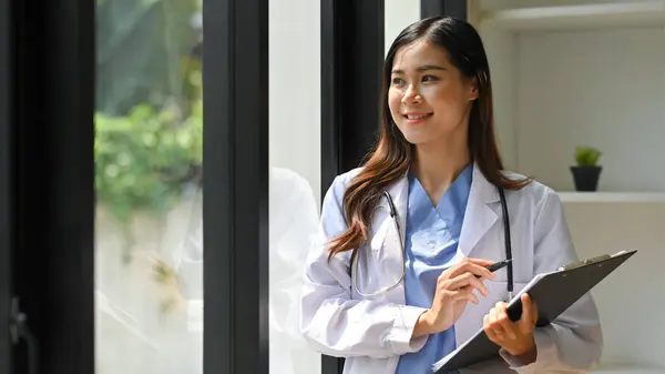 Médica Feminina Positiva Casaco Branco Segurando Forma Médica Olhando Pela — Fotografia de Stock