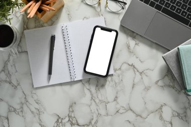 Boş ekranlı akıllı telefon, dizüstü bilgisayar ve mermer masada gözlük. Düz yatış, Üst Görünüm.