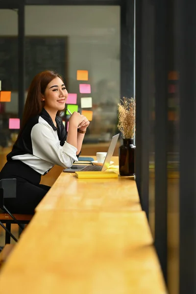 Smiling Millennial Woman Entrepreneur Sitting Counter Office Looking Window Thinking — Stock Photo, Image