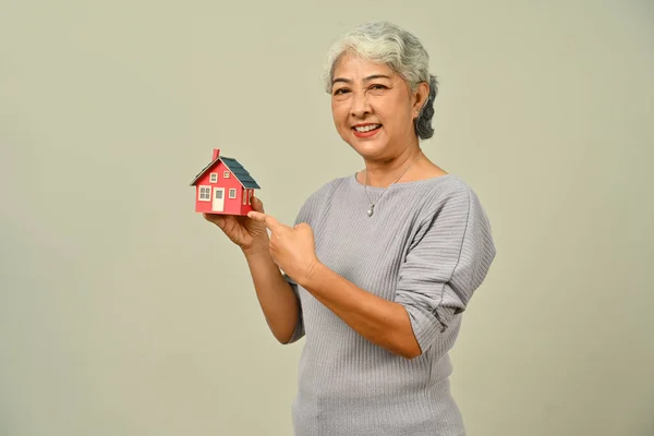 漂亮的成熟女人拥有基于米色背景的小房子模型 房地产 财产和保险概念 — 图库照片