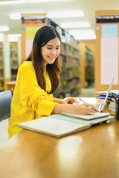 授業の宿題をしたり 図書館のノートパソコンで情報を探したりするアジア系女子学生の姿 教育理念 — ストック写真