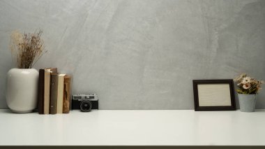 Ofisin içinde retro kamera, kitaplar, resim çerçevesi ve çiçek saksısı var. Metnin için boşluk kopyala.