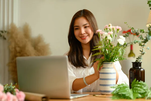 若い女性の花店のオーナーは ラップトップ上のクライアントからの注文をチェック笑顔 小規模事業の概念 — ストック写真