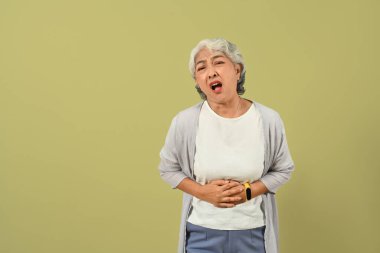 Olgunlaşmamış 60 'lı yaşlarda karın ağrısı, hazımsızlık, mide iltihabı ya da ishalden muzdarip bir kadın.. 