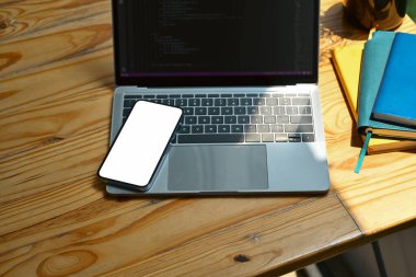 Mockup akıllı telefon dizüstü bilgisayarı ve ahşap masadaki kitaplar. Montaj için beyaz boş ekran Grafik ekranınız.