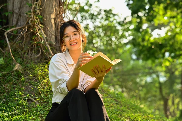 美丽的晴天 亚洲女子在绿草下看书 心情愉悦 — 图库照片