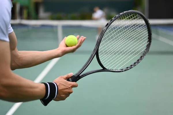 試合中にラケットボールを提供する男性テニスプレーヤーのトリミングイメージ — ストック写真