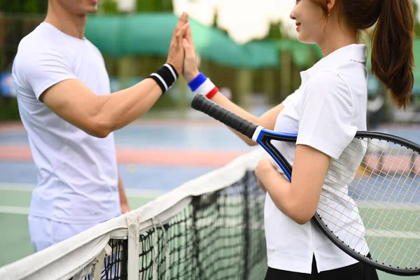 二人の若いテニス選手のショットは テニスコートで互いに高い5以上のネットを与えます — ストック写真
