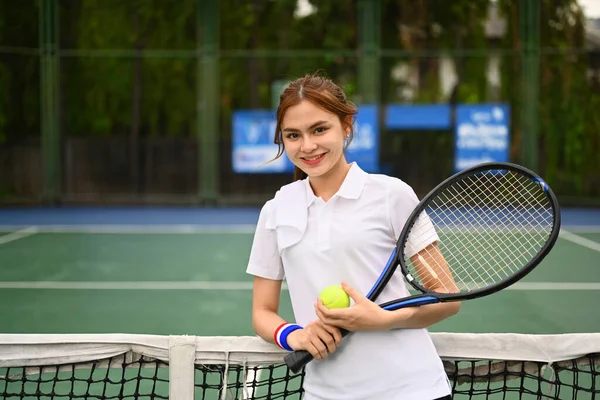 魅力的な女性テニスプレーヤーでラケットとボールスタンディングでネットでザ屋外テニスコート — ストック写真