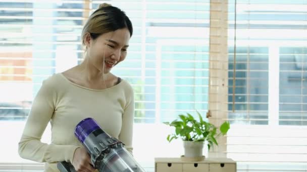 快乐的年轻亚洲女人做家务 用无线吸尘器清洁地板 — 图库视频影像
