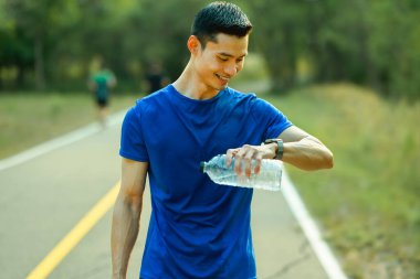 Tatmin olmuş sporcu nabız ve eğitim sonuçlarını kontrol ediyor. Teknoloji sağlığı, sağlık konsepti.