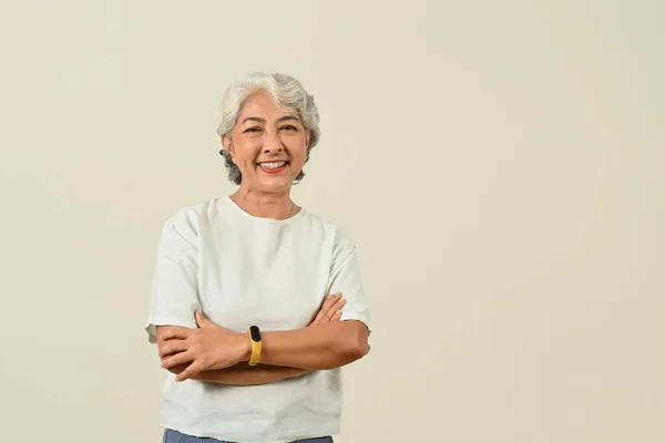 Pozitivní Šedovlasá Starší Žena Stojící Rukama Zkříženýma Přes Zelené Pastelové — Stock fotografie
