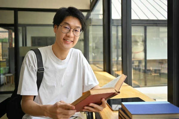 Sorridente Asiatico Uomo Studente Occhiali Seduto Caffetteria Lettura Del Libro — Foto Stock