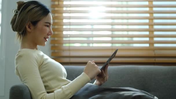 Kanepede Oturan Dizüstü Bilgisayar Kullanan Asyalı Bir Kadının Yavaş Çekim — Stok video