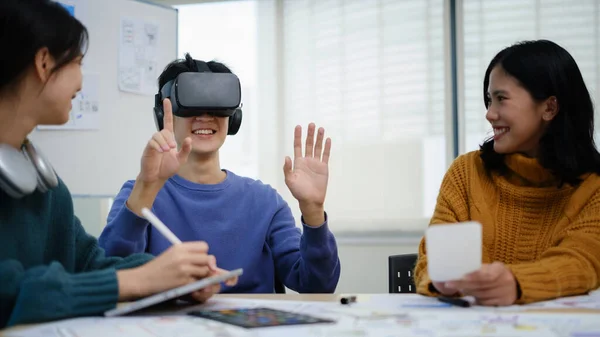 stock image Team of developers is brainstorming, testing virtual reality simulator glasses at meeting, future technology for business concept.