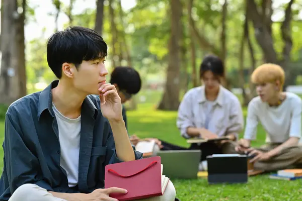 Przemyślany Azjatycki Student Siedzący Zielonej Trawie Przed Budynkiem Uniwersyteckim Edukacja — Zdjęcie stockowe