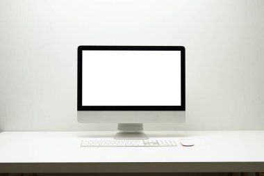 Banka ekran bilgisayarının ön görüntüsü, kablosuz klavye ve beyaz masadaki fare. Web sayfanız için boş ekran veya metin tanıtımı.